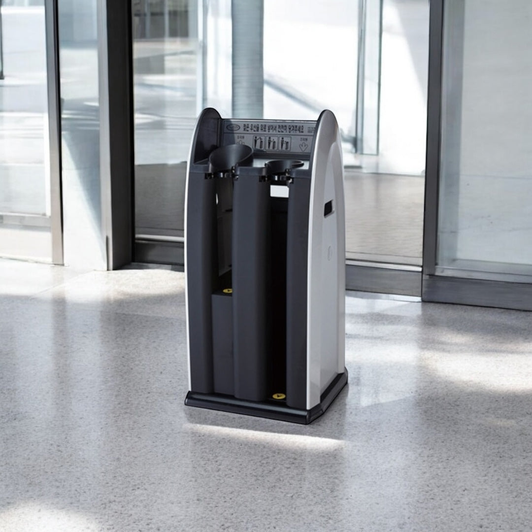 Black and gray umbrella stand in a modern indoor setting with glass walls.
